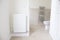 White radiator on wall and ensuite bathroom WC toilet
