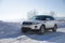 White Range Rover Evoque with a black roof on a winter road on the background of Zhiguli mountains of Samara region