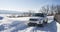 White Range Rover Evoque with a black roof on a winter road on the background of Zhiguli mountains of Samara region