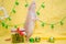 White rat dumbo with cute ears stand on legs near New Year gift on yellow background with Christmas ball, symbol of 2020