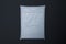 White realistic packet in transparent wrapping on black background. 3d rendering