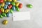 White rectangular Easter tag mockup with Happy Easter chocolate easter eggs on grey stone background