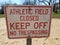 White and red athletic field closed keep off no trespassing sign on dirt