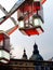 White and red clear glass gondola and detail of giant Ferris wheel in Budapest with church tower in the background