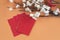 White and red flowers branch with red envelopes on soft orange background.