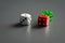 White, red and green dice on dark grey background.