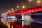 White and red illuminated at Slasko-Dabrowski bridge over Vistula River at night in Warsaw, Poland