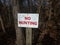 White and red no hunting sign with trees