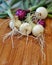 White and red onions with green stems on a wet bamboo cutting bo