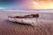 A white and red painted wooden fishing boat on the Paternoster beach in South Africa