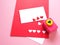 White and red paper, heart-shaped punches and decorations for making a love card on a pink background.