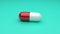 White-Red pills isolated rotating on green background. Seamless looping.