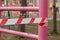 A white and red ribbon prohibits entry to the Playground. Playground swing in the open air prohibiting red tape, infection