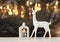 White reindeer on wooden table over chalkboard background with hand drawn chalk illustrations.