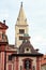 White Renaissance tower by the Baroque church facade