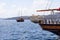 White rescue boat on the bow of a wooden pleasure boat in the old port of the Greek city of Fira.