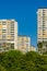 White residential buildings with green plants on the balconies and yellow awnings