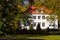 White residential house with a garden in autumn