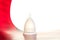 White reusable menstrual cup on a white-red background