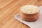 White rice basmati in wooden bowl on brown bamboo board, closeup. Rustic style, healthy dietary cereals background.