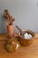 White rice in the earthen brown pot with dried flowers in terracotta vase put on a wood table and gray wall