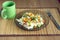 White rice with vegetables on plate over wicker mat