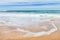 White Ripples of Surf Wave against Golden Sand with Sky