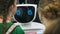 A white robot interacts with a schoolboy at an exhibition of new technologies. The child gets acquainted with