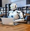 A white robot sits in a cafe with a laptop. AI generated