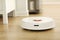 White robot vacuum cleaner cleans the floor from debris,home cleaning with an electric vacuum cleaner,vacuum cleaner electric