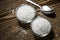 White rock coarse salt in glass bowls on brown wooden table