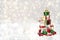 A white rocking horse with red and green gifts stands on white snow. Christmas decoration on a white background.