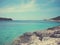 White rocky beach and clear blue sea on a sunny summer day; faded, retro style