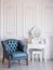 White room with blue retro chair and mirror