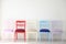 White room with colorful chairs blue yellow red blue purple