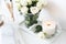 White room interior decor with burning hand-made candle and bouq