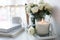 White room interior decor with burning hand-made candle and bouq