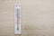 White room thermometer on wooden background