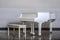 White room with white wooden grand piano and chair