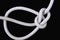 A white rope tied with bowline knot on black background