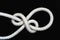 A white rope tied with running bowline knot on black background