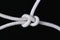 A white rope tied with sheet bend knot on black background