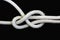 A white rope tied with sheet bend knot on black background