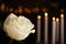 White rose and blurred burning candles on background. Funeral symbol