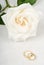 White Rose and Wedding Rings on Textured Paper