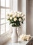 White roses in a vase on the windowsill.