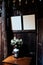 White roses in a vase on a wooden table with photo frames on the wooden wall, Wonderful antique living room decoration
