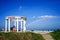 The white rotunda near the beach in the area of Feodosia on the background of blue sky and rainbow over the sea.