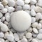 White round big pebble, stone, rock laid on pile of nature pebbles, stones, rocks with copy or text space.