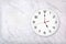 White round wall clock on white natural marble background. Five o`clock